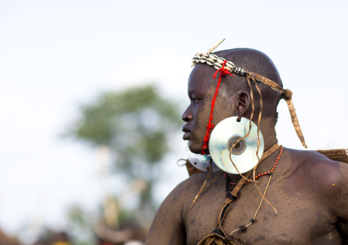 Bodi tribe fat man with cd as earrings during Kael ceremony, Omo valley, Hana Mursi, Ethiopia