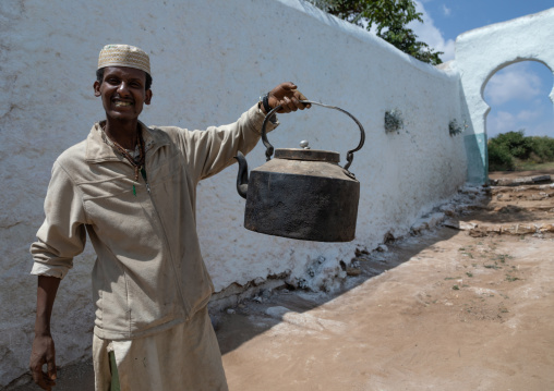 Muslim man holding a huge teapot, Harari Region, Harar, Ethiopia