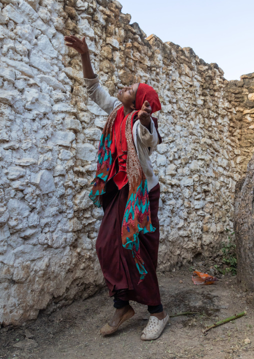 Sufi woman with a red veil into trance during a muslim ceremony, Harari Region, Harar, Ethiopia