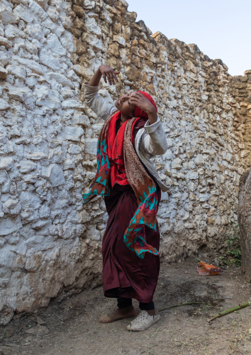 Sufi woman with a red veil into trance during a muslim ceremony, Harari Region, Harar, Ethiopia