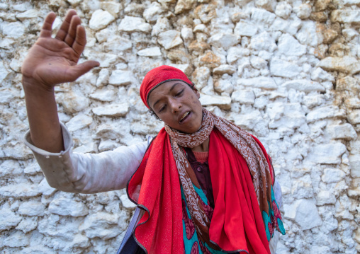 Sufi woman with a red veil into trance during a muslim ceremony, Harari Region, Harar, Ethiopia