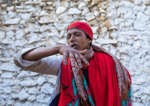 Sufi woman with a red veil into trance during a muslim ceremony, Harari Region, Harar, Ethiopia