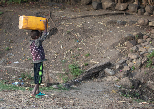 Ethiopian boy carrying water jerrican on his head, Amhara region, Senbete, Ethiopia
