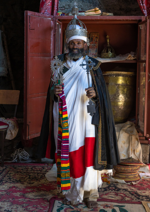 Ethiopian orthodox priest in nakuto lab rock church holding a cross, Amhara Region, Lalibela, Ethiopia