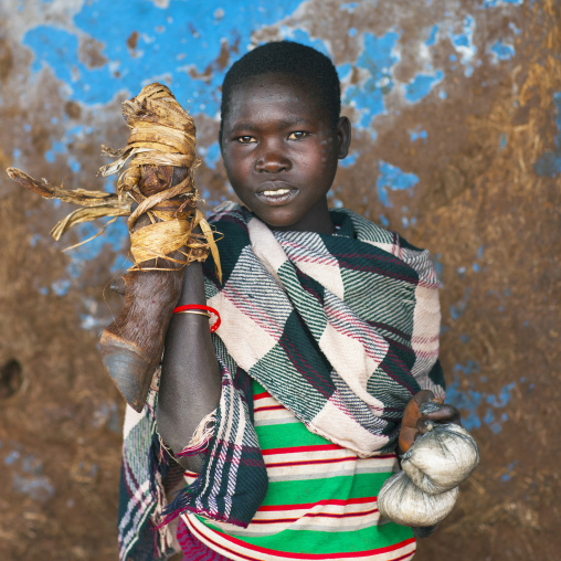 Woman from menit tribe holding an animal's leg, Jemu, Omo valley, Ethiopia