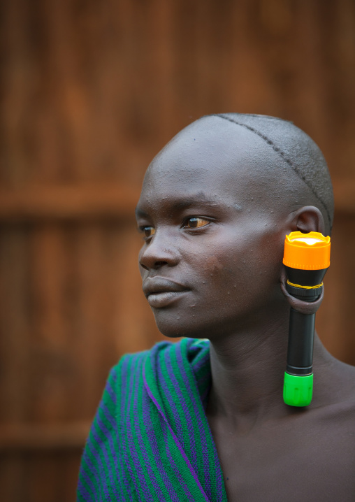 Suri tribe man with an enlarged ear decorated with a lamp, Kibish, Omo valley, Ethiopia
