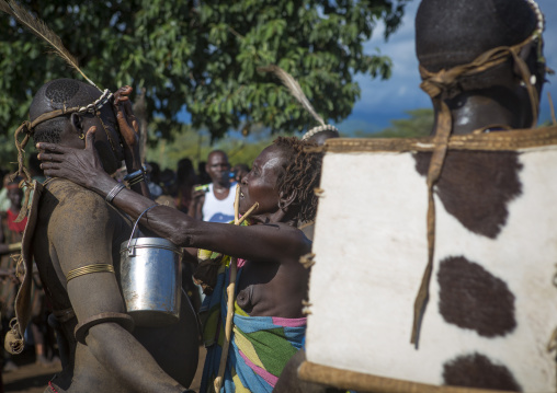 Bodi Tribe Woman Putting Water On The Face Of A Fat Man During Kael Ceremony, Hana Mursi, Omo Valley, Ethiopia