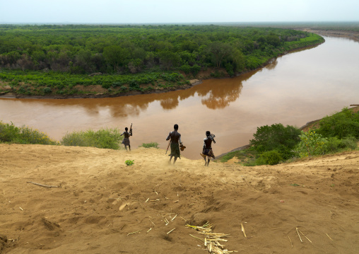 Three Karo People Heading Down A Hill To The River Omo Valley Ethiopia