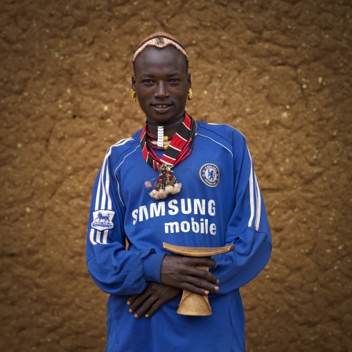 Chelsea Football Club Hamar Tribe Fan With Necklaces Holding A Headreast In Turmi, Omo Valley, Ethiopia