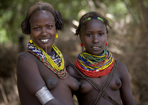 Portrait Of Two Young Dassanech Tribe Girls With Traditional Jewels And Hairstyle, Omorate, Omo Valley, Ethiopia