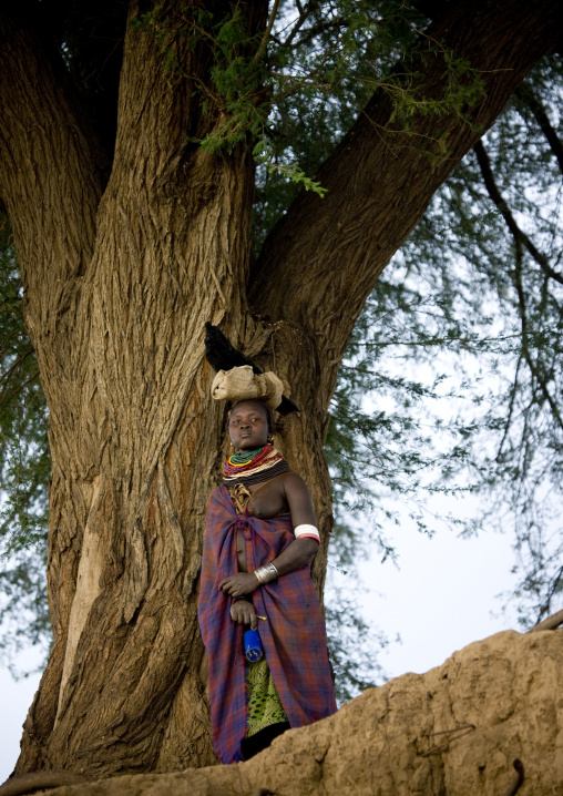 Nyangatom Tribe Woman Under A Tree Carrying A Bag On Her Head, Omo Valley, Kangate, Ethiopia