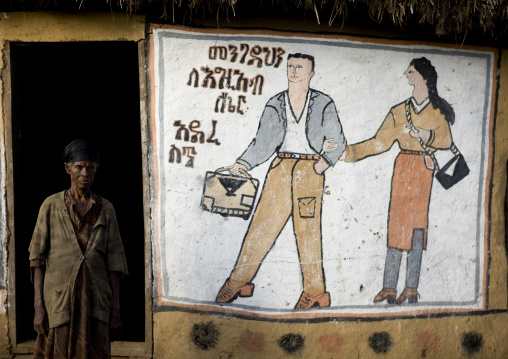 Couple painted on a wall with a senior black woman standing near, Addis ababa, Ethiopia