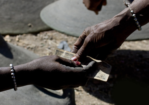 Woman paying a seller, Bati, Amhara region, Ethiopia