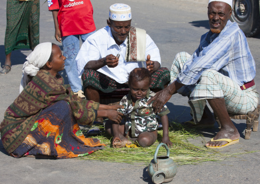 Baby having hair shaved at aid el kebir celebration, Assaita, Afar regional state, Ethiopia