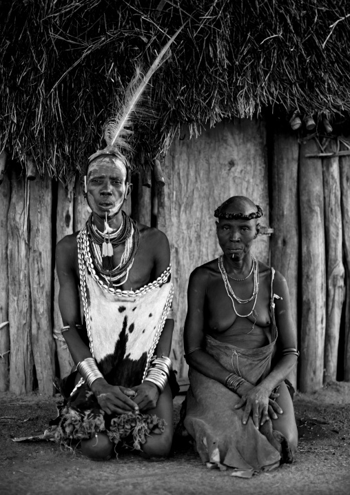 Black And White Portrait Of A Karo Tribe Couple In Traditional Clothes Posing Outside Their House, Korcho Village, Omo Valley, Ethiopia