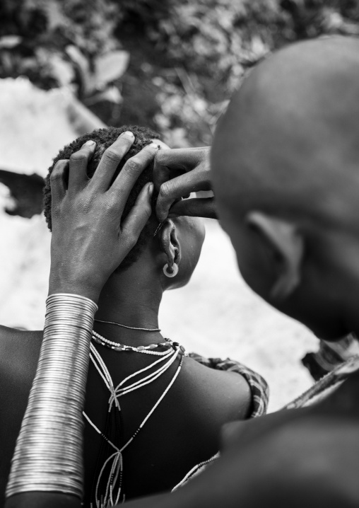 Suri tribe woman having a haircut, Kibish, Omo valley, Ethiopia