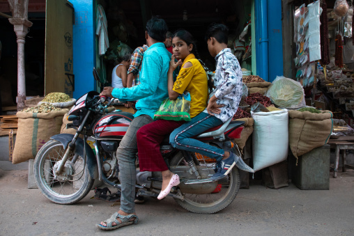 Indian family riding a scooter in the street, Rajasthan, Bikaner, India