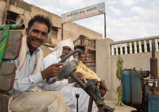 Indian man driving a tractor in a farm, Rajasthan, Baswa, India