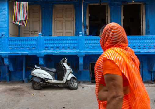 Indian woman in front of an old blue house of a brahmin, Rajasthan, Jodhpur, India
