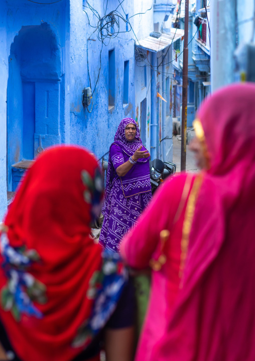 Rajasthani women in front of old blue houses, Rajasthan, Bundi, India