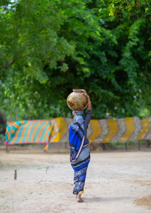 Indian woman carrying a jar on her head, Rajasthan, Baswa, India