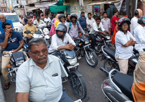Indian riders ride motorbikes on busy road, Rajasthan, Bikaner, India