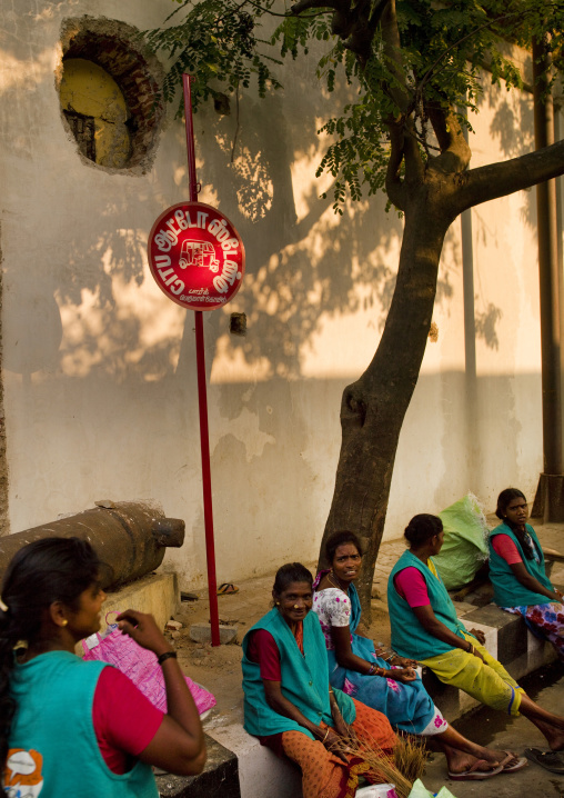 Group Of Workers Sitting On The Curb Waiting For The Bus, Pondicherry, India