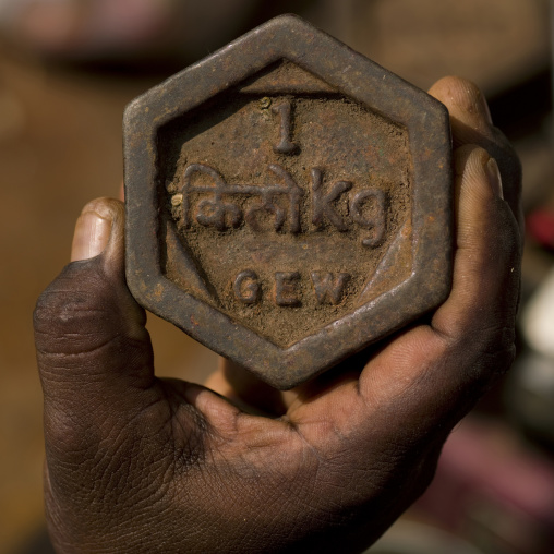 Hand Holding A Rusted Metal Weight Of One Kilogram, Madurai, India