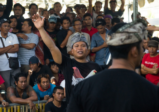 Men Taking The Money For The Bets During A Cockfigting Event