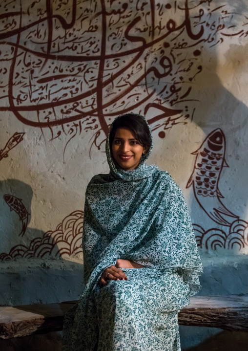 portrait of beautiful young veiled woman in front of iranian calligraphy, Qeshm Island, Salakh, Iran