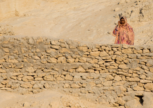 a bandari woman wearing a traditional mask calling with a mobile phone, Qeshm Island, Salakh, Iran