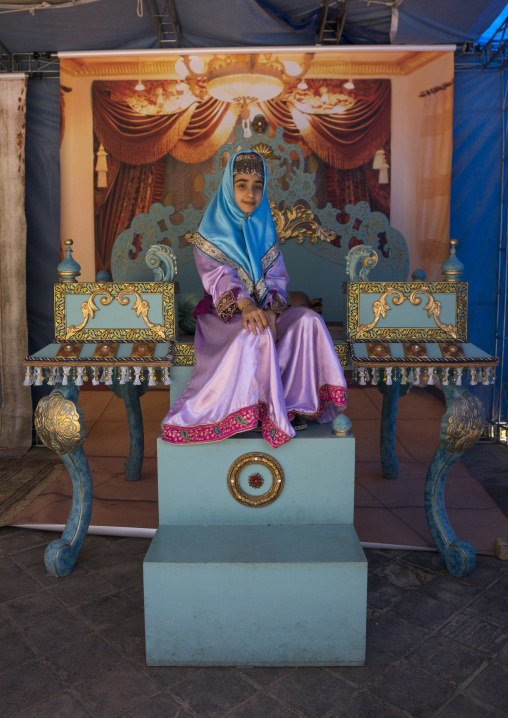 Girl pausing in traditional clothing for a photo souvenir in the saadabad palace, Shemiranat county, Tehran, Iran