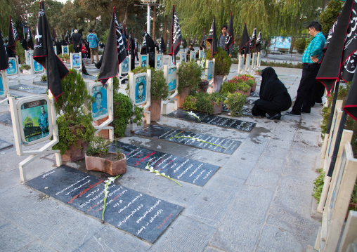 Families praying on the tomb of their sons killed in the Iran Iraq war in the Rose garden of martyrs cemetery, Isfahan Province, Isfahan, Iran