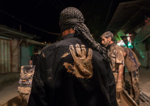 Iranian shiite muslim men gather around a bonfire after rubbing mud on their bodies during the Kharrah Mali ritual to mark the Ashura ceremony, Lorestan Province, Khorramabad, Iran