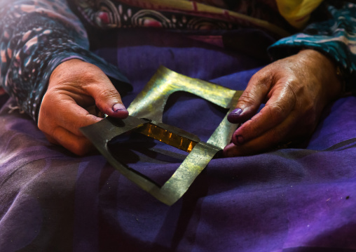a bandari woman sewing a traditional burqa mask, Qeshm Island, Salakh, Iran