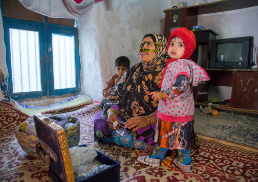 a bandari woman wearing a traditional mask called the burqa with her children, Qeshm Island, Salakh, Iran