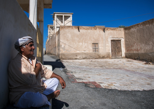 man sitting in front of a wind tower, Hormozgan, Bandar-e Kong, Iran