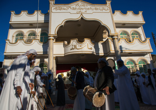 men dressed in white dancing with sticks during a wedding ceremony, Hormozgan, Bandar-e Kong, Iran