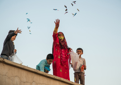 women with face masks throwing sweets to kids during a wedding, Hormozgan, Kushkenar, Iran