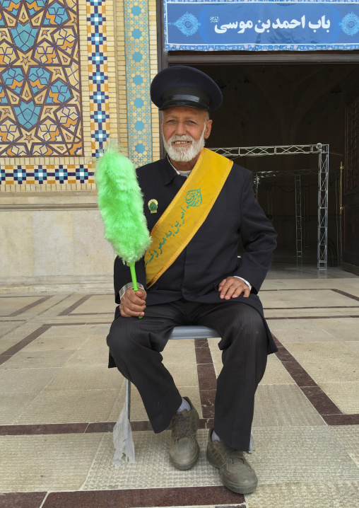 Guard with a green feather duster at the shah-e-cheragh mausoleum, Fars province, Shiraz, Iran