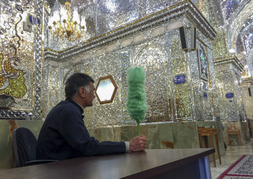 Guard with a green feather duster at the shah-e-cheragh mausoleum, Fars province, Shiraz, Iran