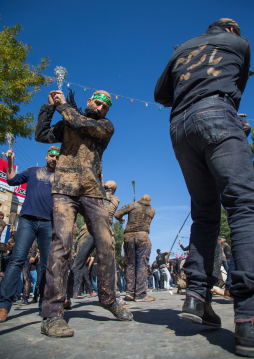 Iranian Shiite Men Covered In Mud Are Beating Themselves With Iron Chains During Ashura, The Day Of The Death Of Imam Hussein, Kurdistan Province, Bijar, Iran