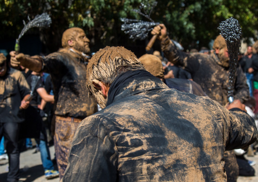 Iranian Shiite Men Covered In Mud Are Beating Themselves With Iron Chains During Ashura, The Day Of The Death Of Imam Hussein, Kurdistan Province, Bijar, Iran