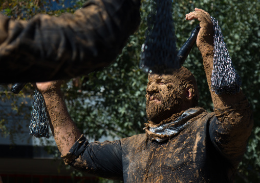 Iranian Shiite Men Covered In Mud Are Beating Themselves With Iron Chains During Ashura, The Day Of The Death Of Imam Hussein, Kurdistan Province, Bijar, Iran