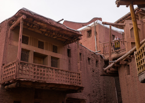 Iranian Woman Standing At The Balcony Of An Ancient Building In Zoroastrian Village, Isfahan Province, Abyaneh, Iran