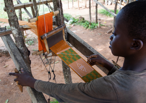 African man from Baoulé tribe weaving in a traditional textile factory, Région des Lacs, Bomizanbo, Ivory Coast