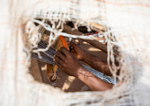 African man from Senufo tribe weaving in a traditional textile factory, Savanes district, Waraniene, Ivory Coast
