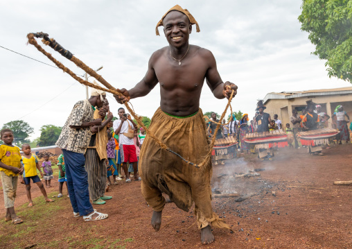Young Senufo shirtless man dancing the Ngoro with a whip during a ceremony, Savanes district, Ndara, Ivory Coast