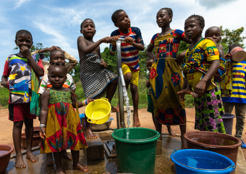 African children collecting water from a well with a pump, Bafing, Yo, Ivory Coast