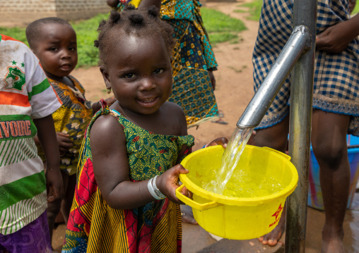 African children collecting water from a well with a pump, Bafing, Yo, Ivory Coast